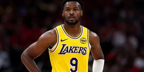 Joueur de basket en uniforme jaune des Lakers sur le terrain.
