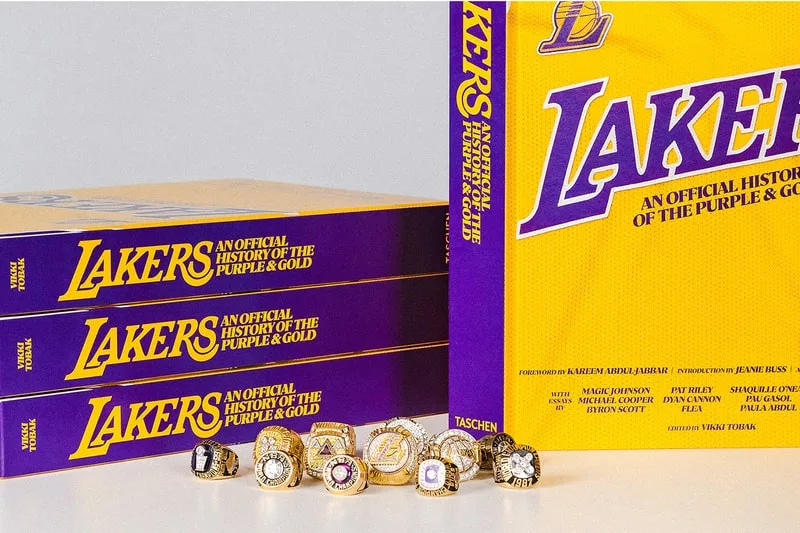 Livres des Lakers et bagues de championnat sur une table.