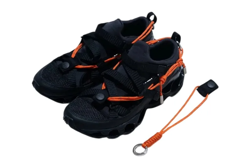 Chaussures noires avec cordons orange et accessoires.