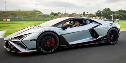 Supercar futuriste grise roulant sur un circuit, vue de profil