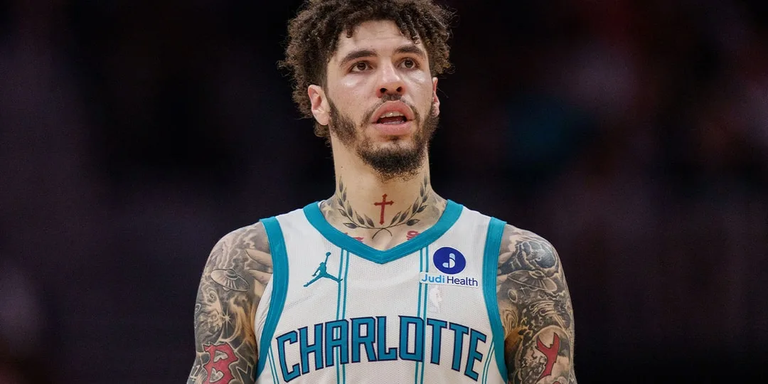 Joueur de basket avec un maillot Charlotte et tatouages.