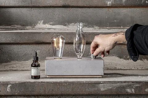Diffuseur en béton avec ampoule vintage et fiole parfumée.