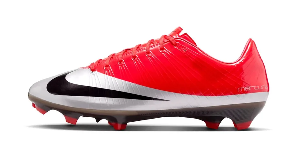 Chaussure de football rouge et blanche avec logo noir sur le côté.