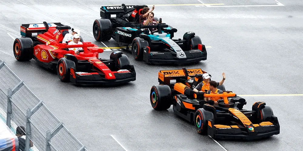 Voitures de course en briques LEGO sur une piste avec pilotes agitant la main.