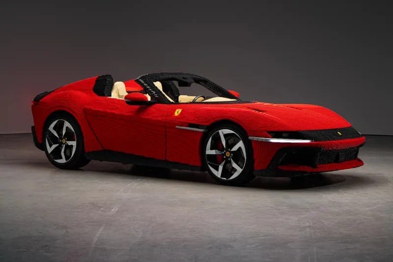 Voiture rouge et noire en LEGO avec détails réalistes, sur fond neutre.