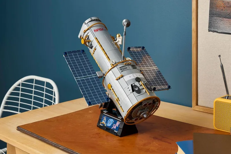 Modèle réduit de télescope spatial sur une table en bois.