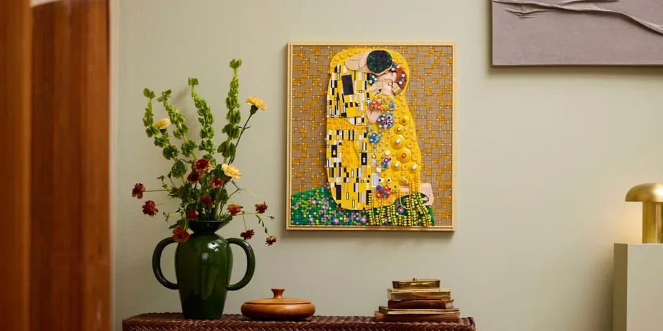 Tableau coloré et fleurs dans un vase vert sur une table.
