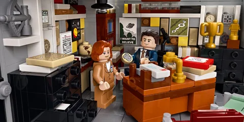 Figurines LEGO dans un bureau rempli de dossiers et trophées, inspiré d'une série TV.