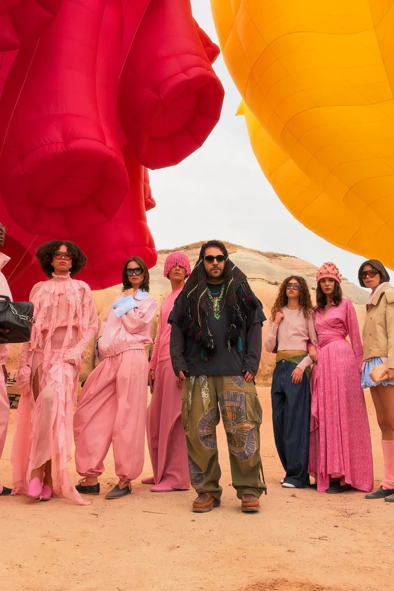 Groupe de personnes en tenue colorée sous des ballons géants.