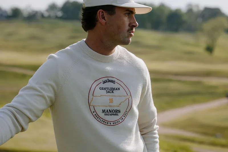 Homme avec pull logo Jack Daniel's sur un terrain de golf.