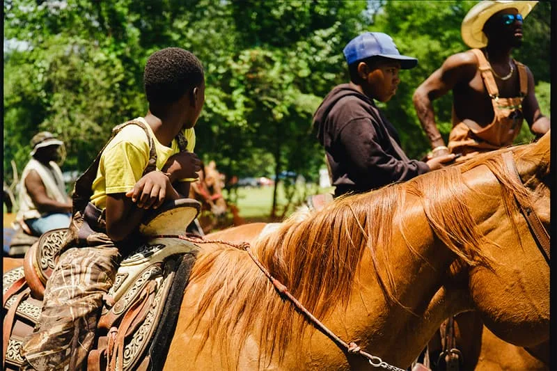 Deux enfants à cheval dans un parc ombragé.