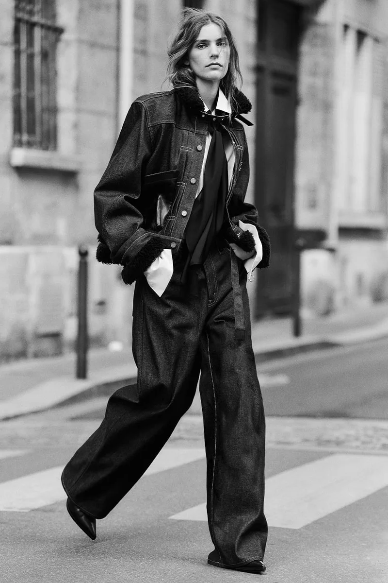 Personne marchant en veste et pantalon en jean, style décontracté urbain.