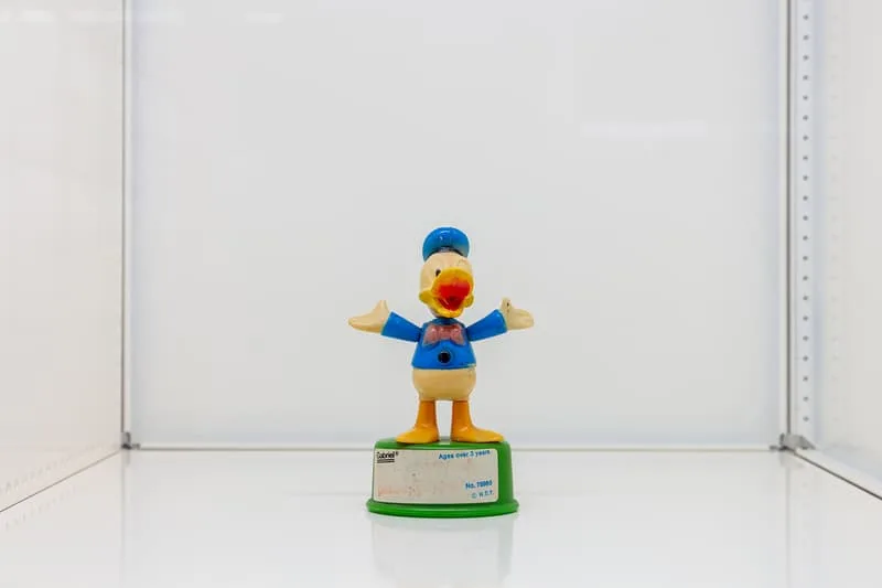 Figurine de canard avec un chapeau bleu sur fond blanc.