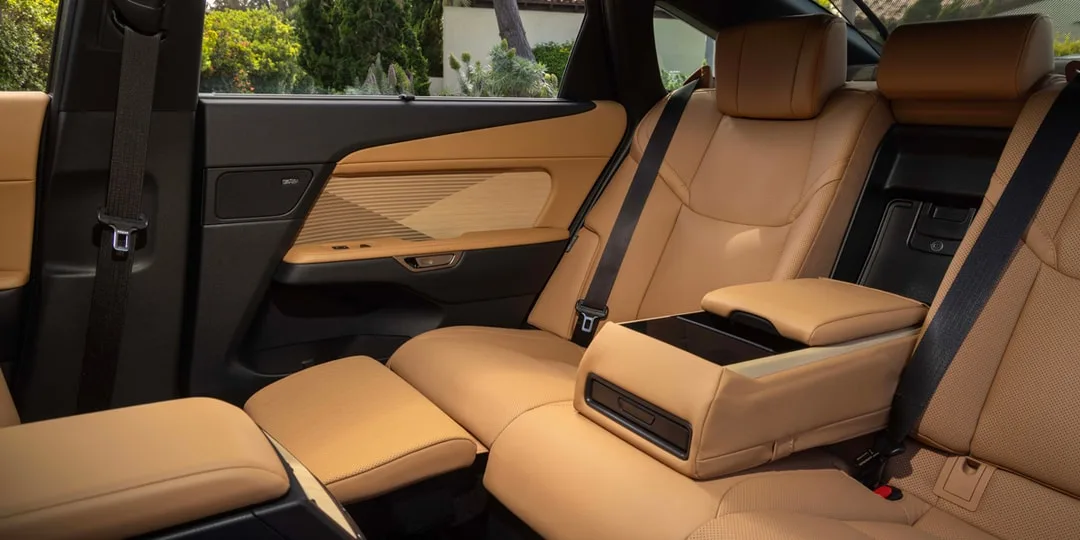 Intérieur de voiture avec sièges en cuir beige et accoudoir central.