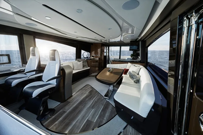 Intérieur moderne d'un yacht avec sièges en cuir et grandes fenêtres.