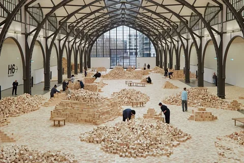 Installation artistique avec blocs de bois dans grand hall.