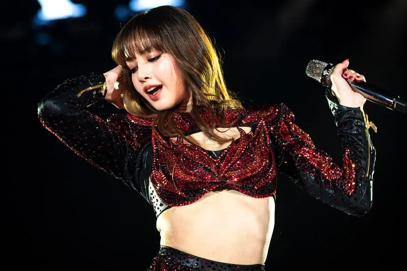 Chanteuse en tenue rouge scintillante sur scène avec micro.