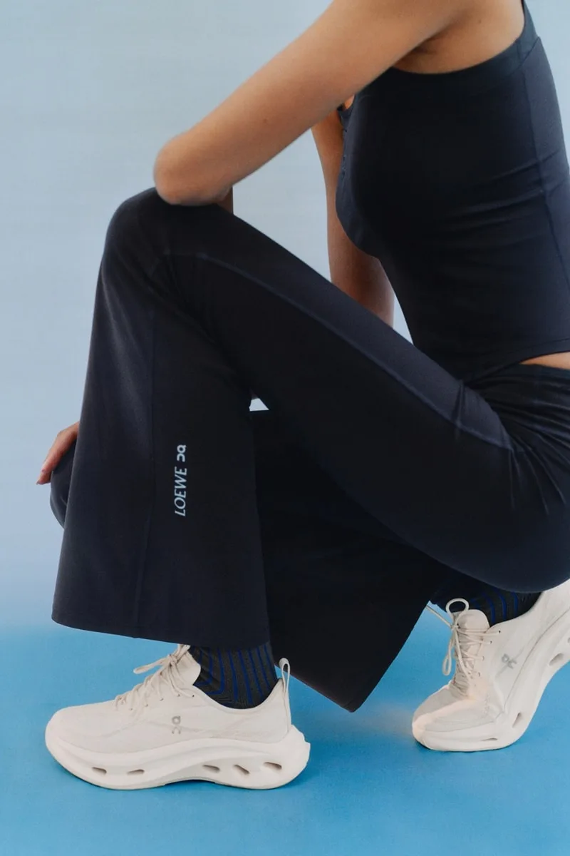 Personne accroupie en tenue de sport avec baskets blanches.