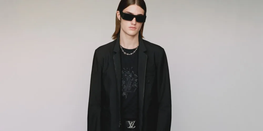 Homme en lunettes de soleil et blazer noir, style moderne et chic.