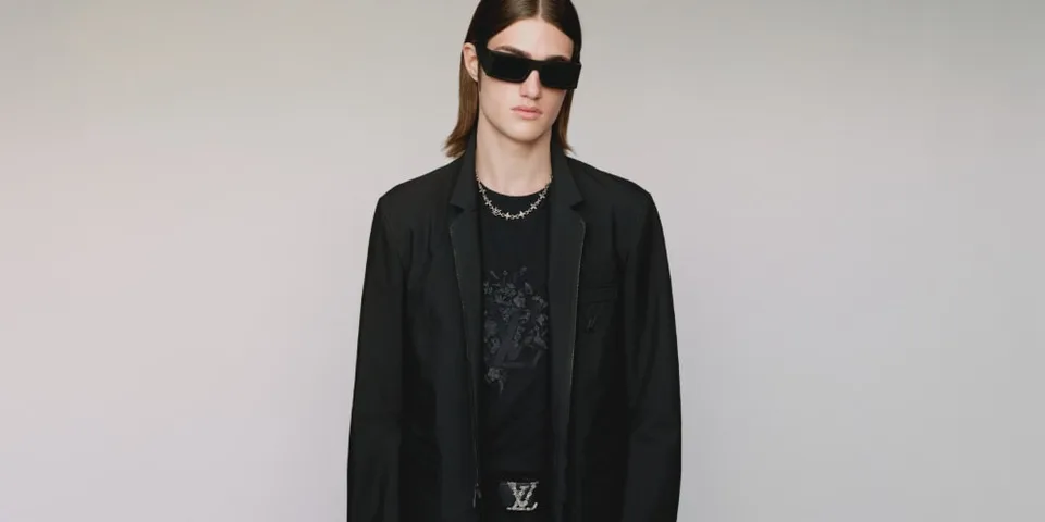 Homme en lunettes de soleil et blazer noir, style moderne et chic.