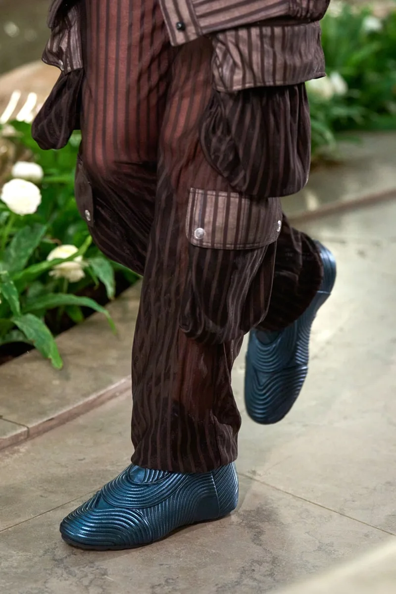 Homme en tenue rayée avec chaussures modernes bleues.