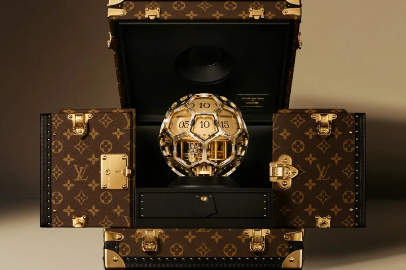 Ballon d'or dans un coffre Louis Vuitton ouvert, luxe et élégance.