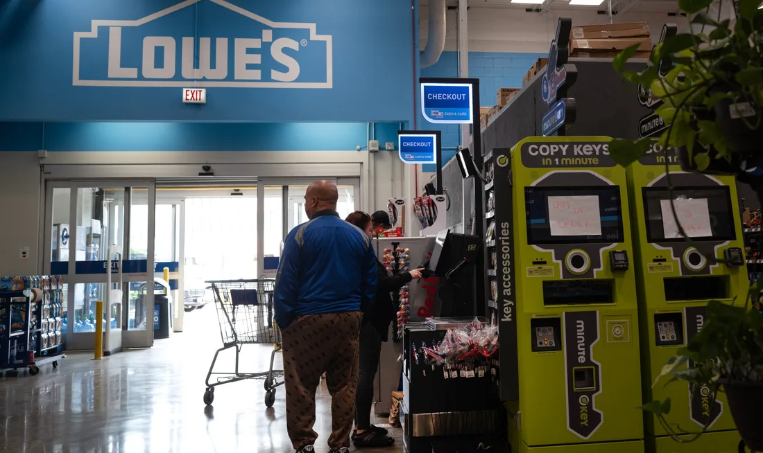 Clients dans un magasin Lowe's près du service de clés et de caisses.