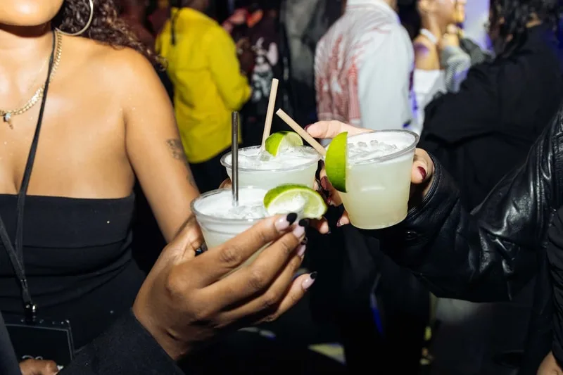 Personnes trinquant avec des cocktails lors d'une fête.