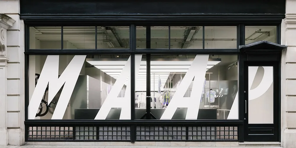 Façade de magasin avec grandes lettres MAAP sur vitre.