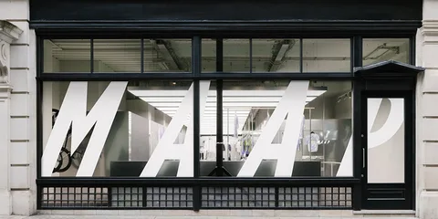 Façade de magasin avec grandes lettres MAAP sur vitre.