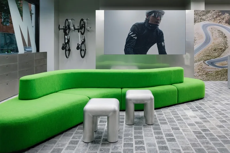 Intérieur moderne avec canapé vert et vélos muraux.