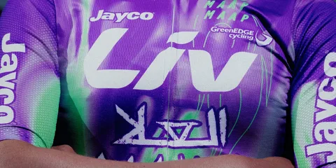 Maillot violet et vert avec logos de sponsors sur cycliste.