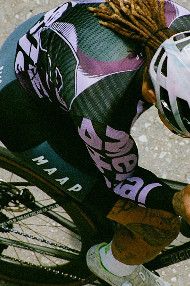 Cycliste professionnel en tenue avec casque blanc et vélo.