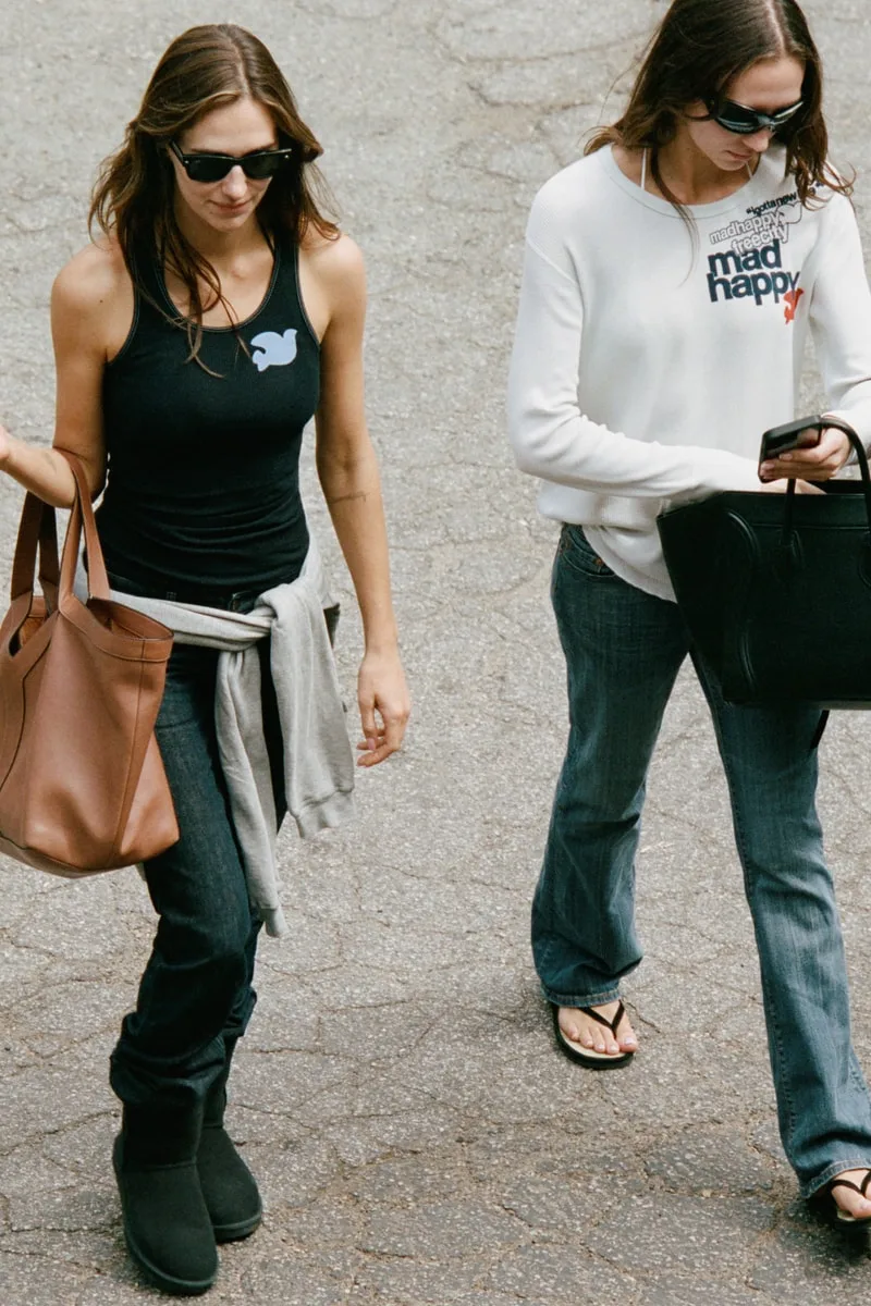 Deux personnes marchant avec sacs à main, portant des lunettes de soleil.