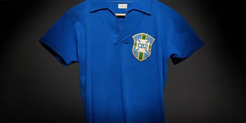 Maillot de football bleu avec écusson vert et jaune, écrit CBD.