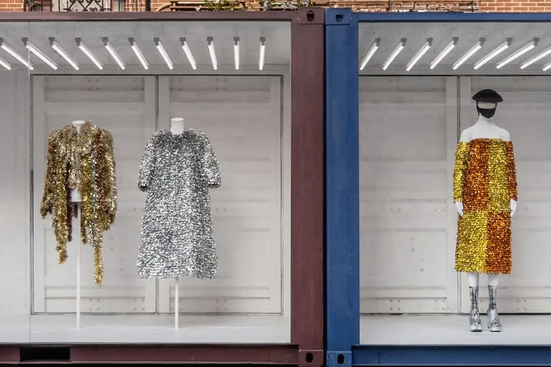 Deux mannequins vêtus de vêtements scintillants dans une vitrine.