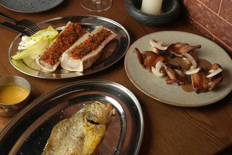 Assortiment de plats gastronomiques sur table en bois.