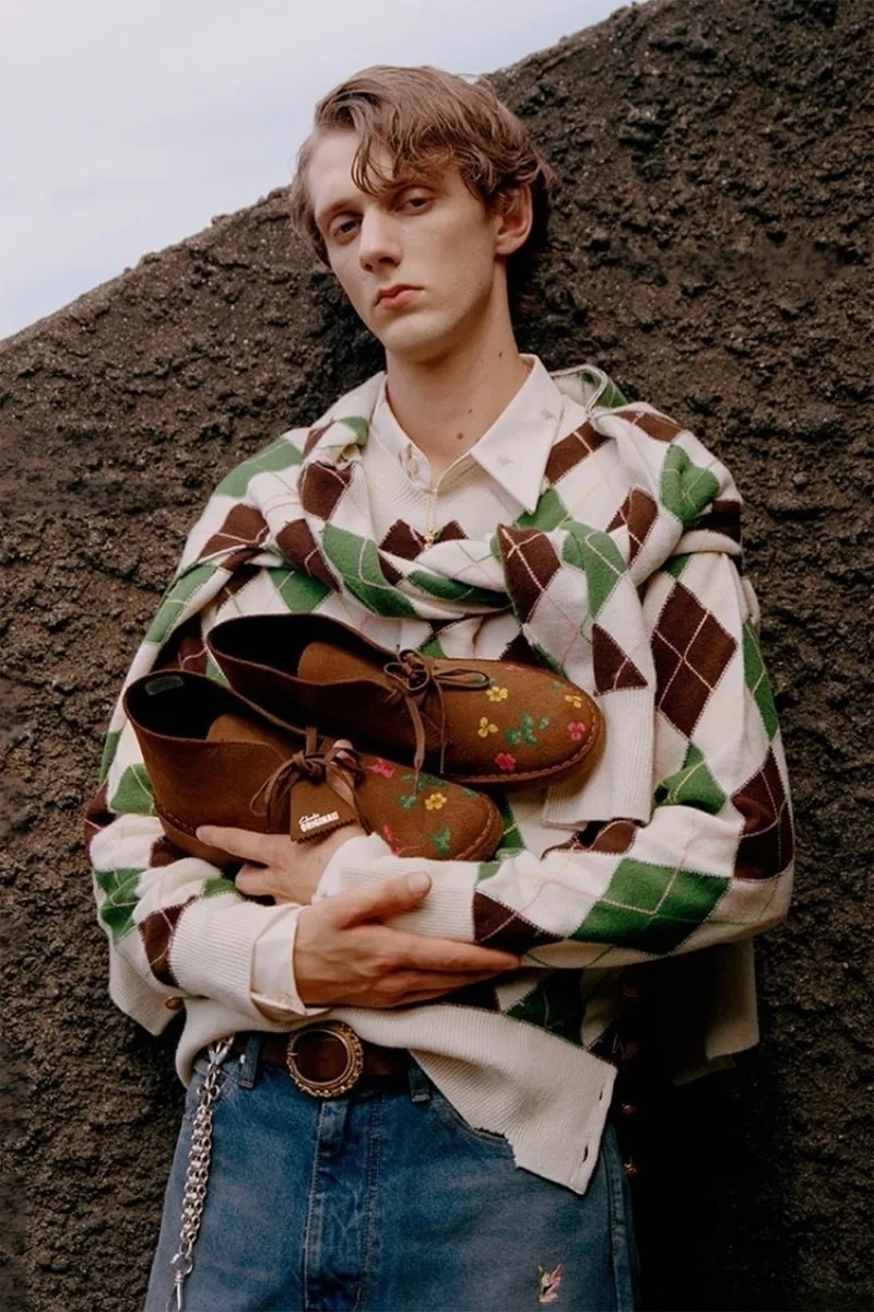 Homme avec pull à motifs et chaussures marron décorées.