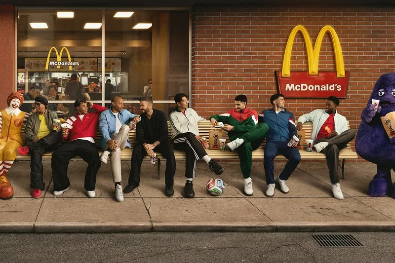 Groupe d'hommes assis devant McDonald's près des mascottes.