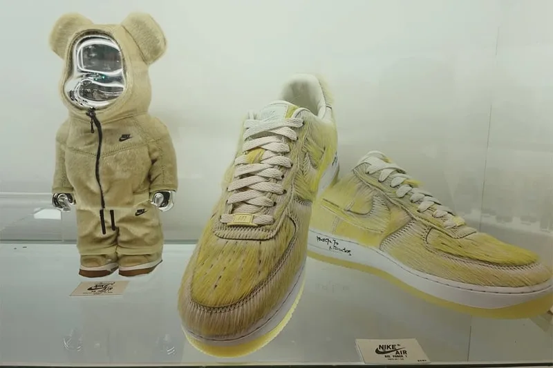 Vitrine avec ours en peluche et basket jaune Nike exposée.