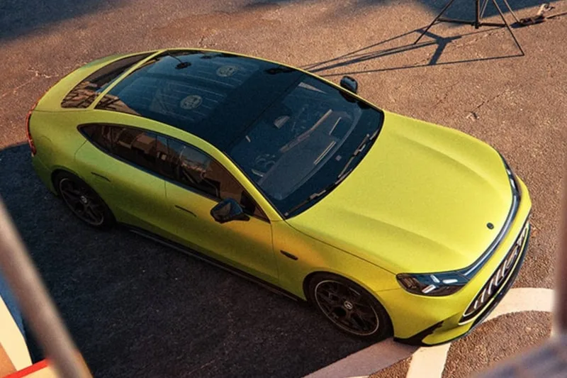 Voiture verte vue de dessus sur un sol pavé.