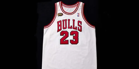 Maillot de basket blanc avec numéro rouge 23 et texte 'Bulls' devant.