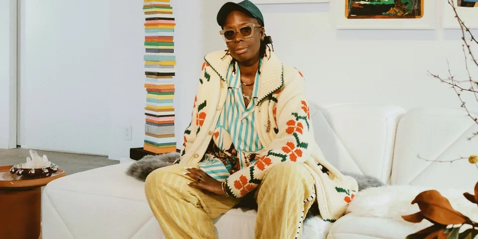 Personne assise sur un canapé avec un style vestimentaire coloré et décontracté.