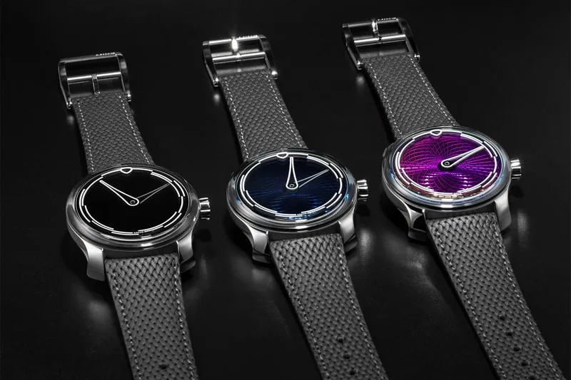 Trois montres avec bracelets argentés et cadrans colorés sur fond noir.