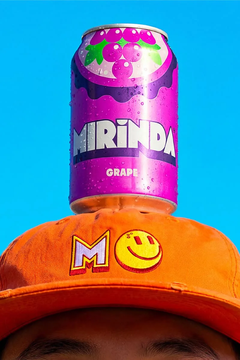 Canette violette de soda Mirinda sur une casquette orange