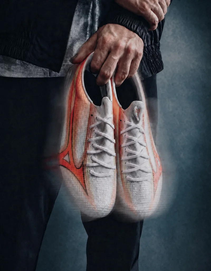 Homme tenant des chaussures de sport blanches et orange floues