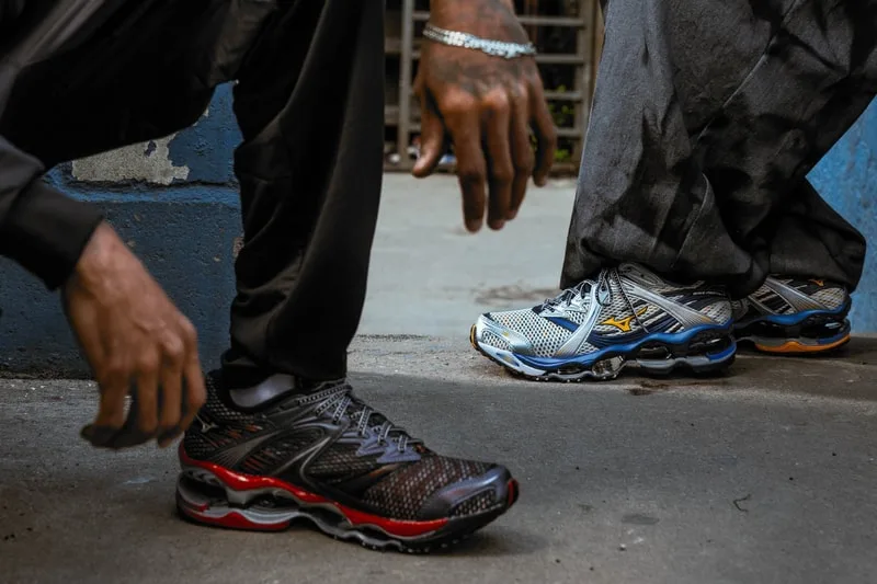 Deux personnes avec des baskets colorées sur un trottoir.
