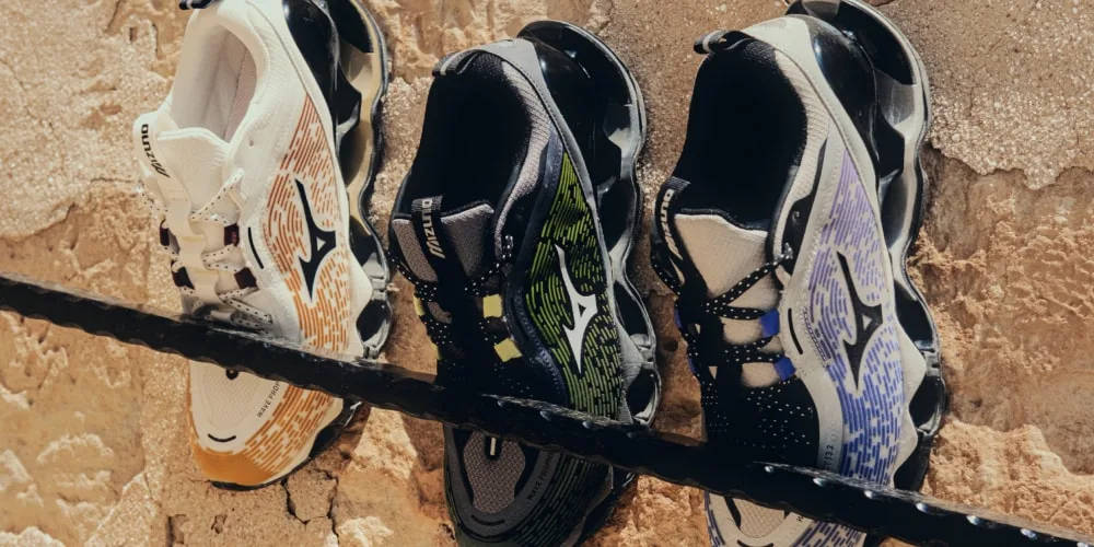 Trois chaussures de sport colorées sur fond en pierre.