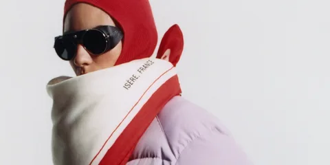 Personne aux lunettes de soleil, écharpe rouge et blanche, bonnet rouge.