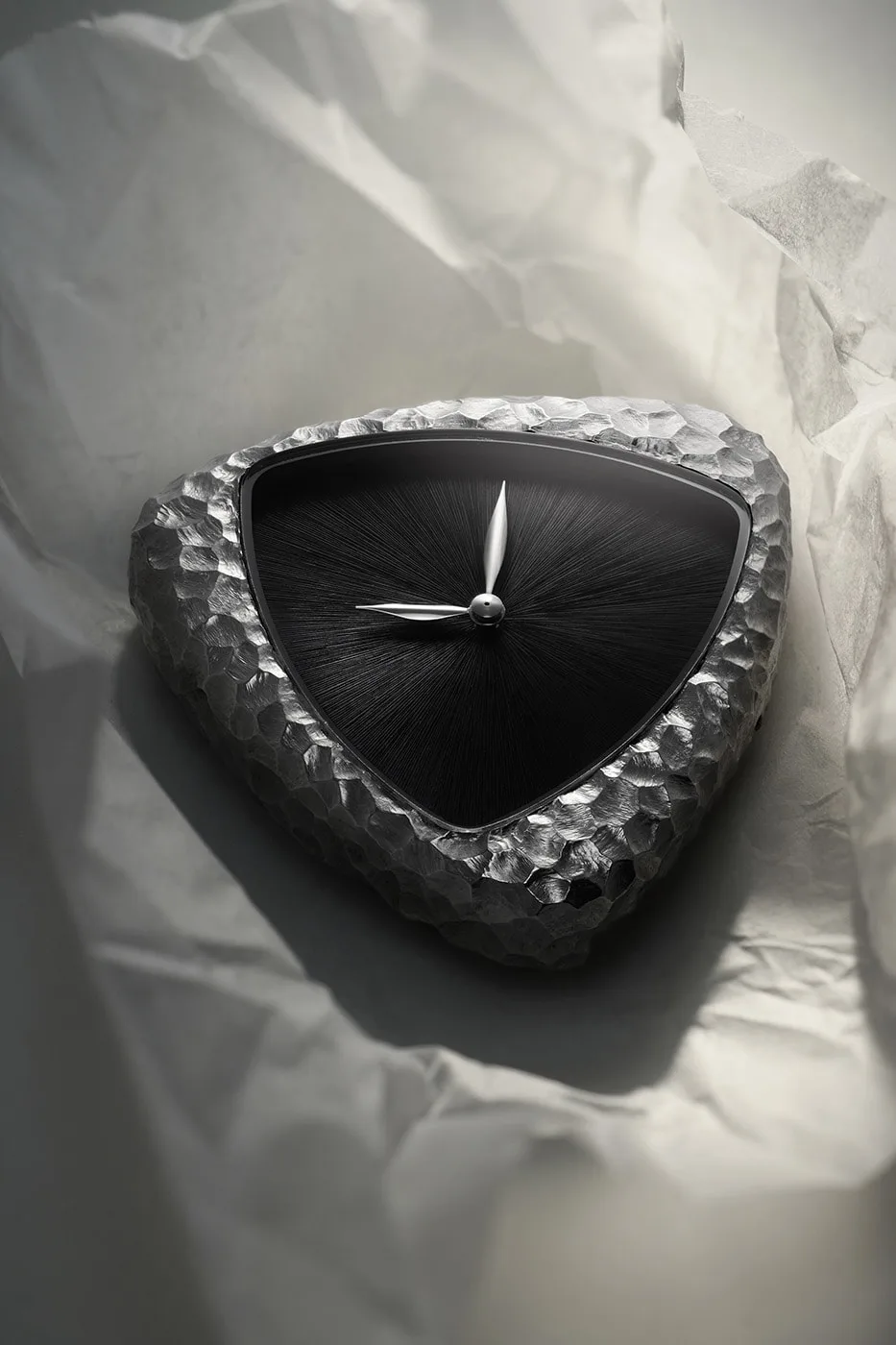 Montre au design triangulaire avec texture métallique et cadran noir.